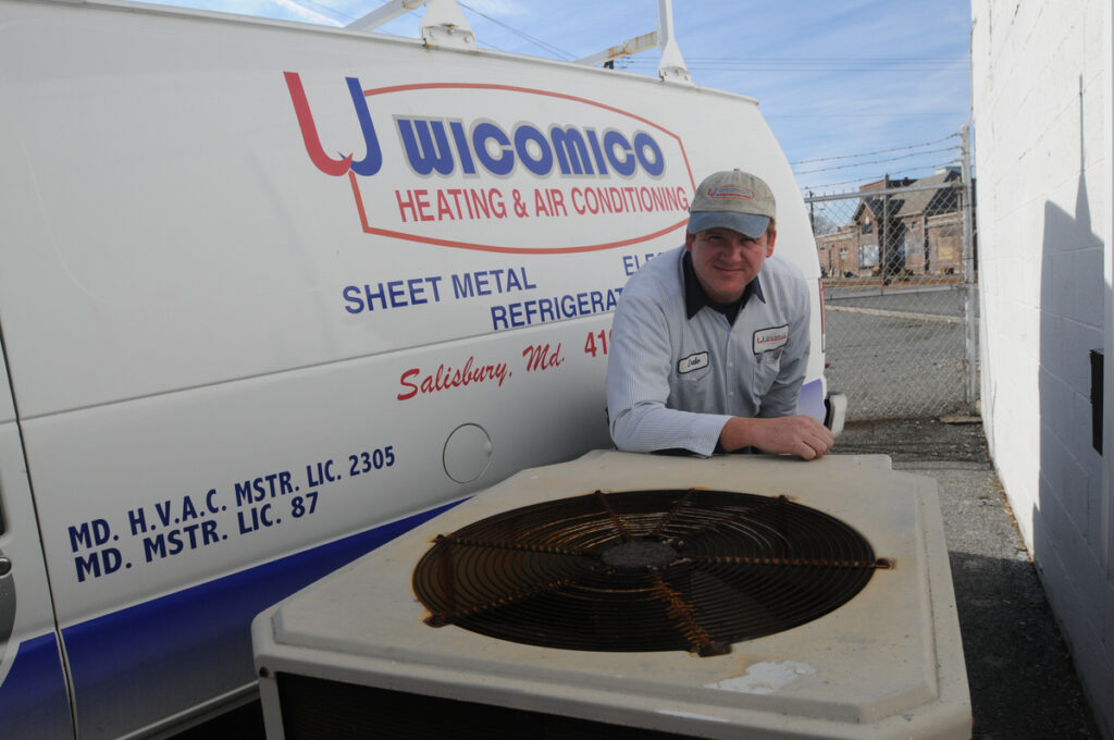 Wicomico tech standing next to outdoor unit infront of van